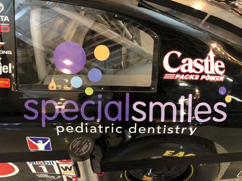 closeup side of vehicle with logo of dental on black car