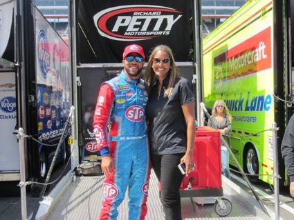 doctor dentist standing next to famous racing driver in public racing event