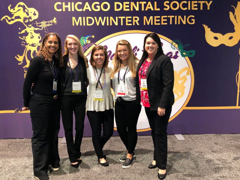 staff and doctor in dental society meeting black pants smiling