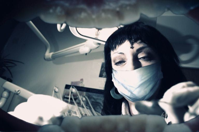 inside of the mouth view of dentist cleaning teeth