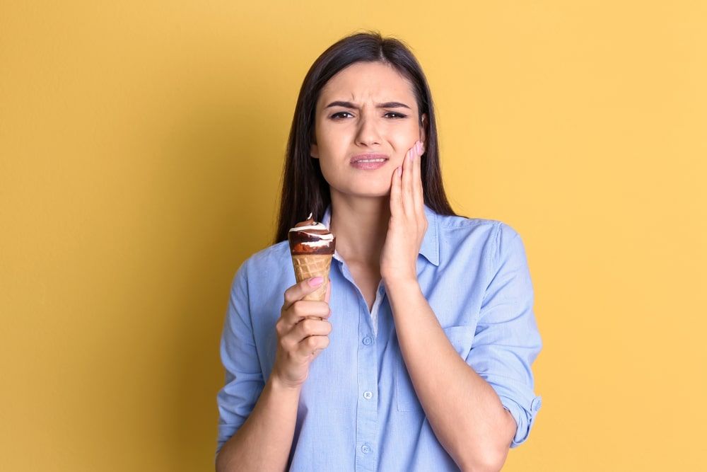 Woman eating ice cream with tooth sensitivity