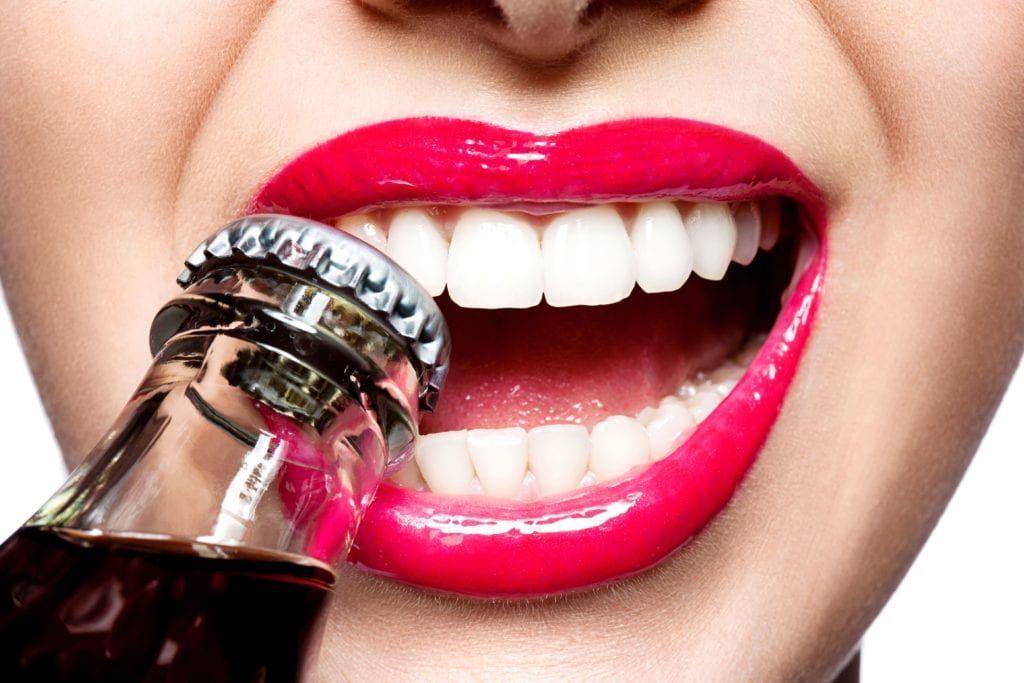teeth biting bottle cap