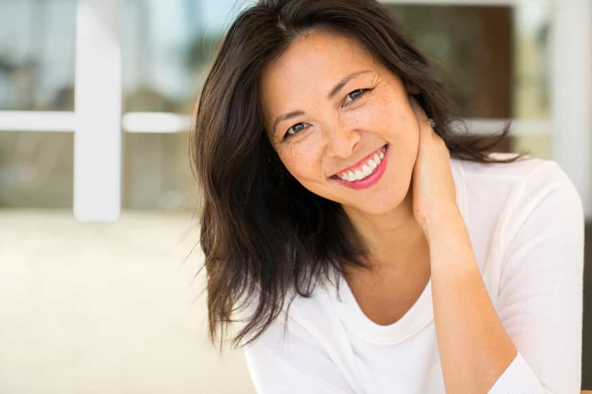 woman smiling with a hand behind her neck